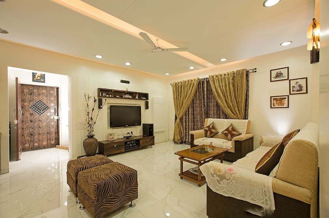 Living-room-accommodates-a-Track-Armed-Sofa-Sets-Wooden-Coffee-Table-Pair-of-Ottomans-Wooden-TV-Unit-with-Lower-Drawers-Upper-Open-Shelf-Box Design Detail Banner 0