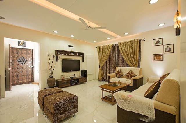 Living-room-accommodates-a-Track-Armed-Sofa-Sets-Wooden-Coffee-Table-Pair-of-Ottomans-Wooden-TV-Unit-with-Lower-Drawers-Upper-Open-Shelf-Box Swiper Content 0