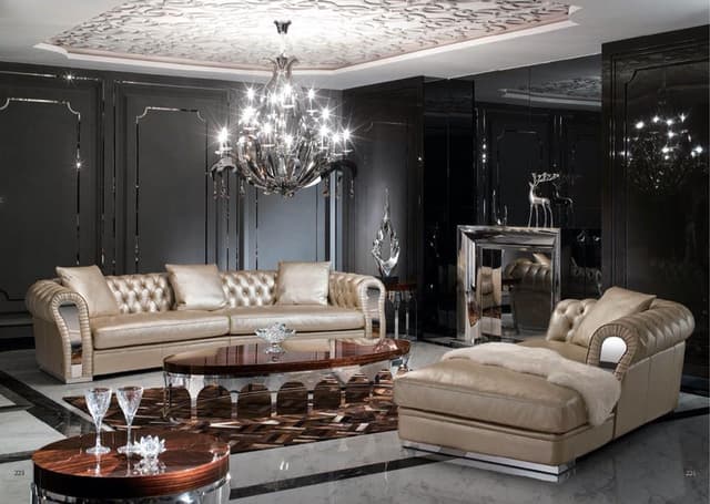 Luxurious-Living-Room-with-a-Chesterfield-Sofa-Chaise-Lounger.-The-Room-includes-an-Oval-shaped-Center-Table-with-Wooden-top-Arched-Shaped-SS-Legs-Side-Tables-with-Decor-Pieces Swiper Content 0