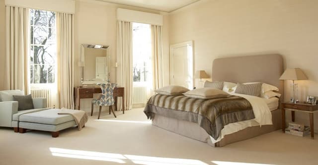 Master-Bedroom-incorporating-Beige-Shaded-Upholstered-Double-Bed-High-Upholstered-Headboard-Wooden-Side-Table-with-Drawer-Table-Lamp-above-Wooden-Dressing-Table-with-Table-Lamps. Swiper Content 0
