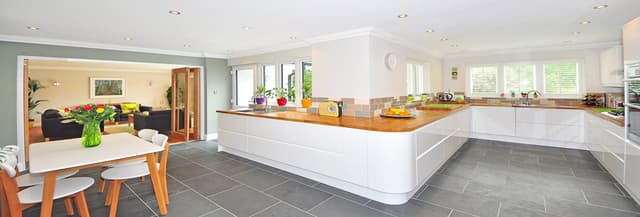 Minimalist-designed-Large-Kitchen-with-White-Lower-Cabinets-Wooden-Countertops-Built-in-Stove-with-Chimney Swiper Content 0