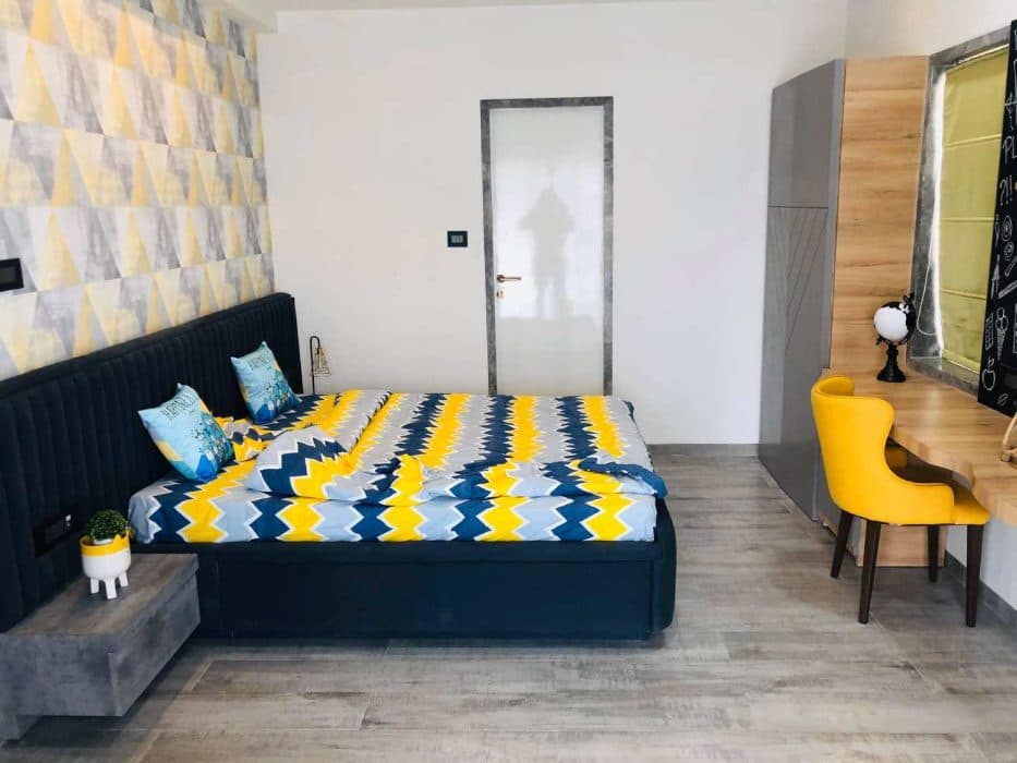 Modern-Bedroom-designed-with-a-Bright-Accent-Wall-with-Yellow-Blue-Colour-Geometric-Wallpaper-2 Design Detail Banner 1