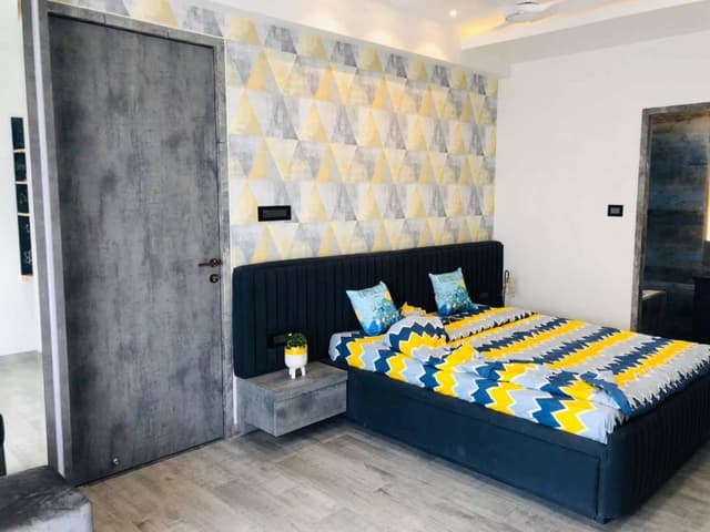 Modern-Bedroom-designed-with-a-Bright-Accent-Wall-with-Yellow-Blue-Colour-Geometric-Wallpaper-3-1 Swiper Content 2