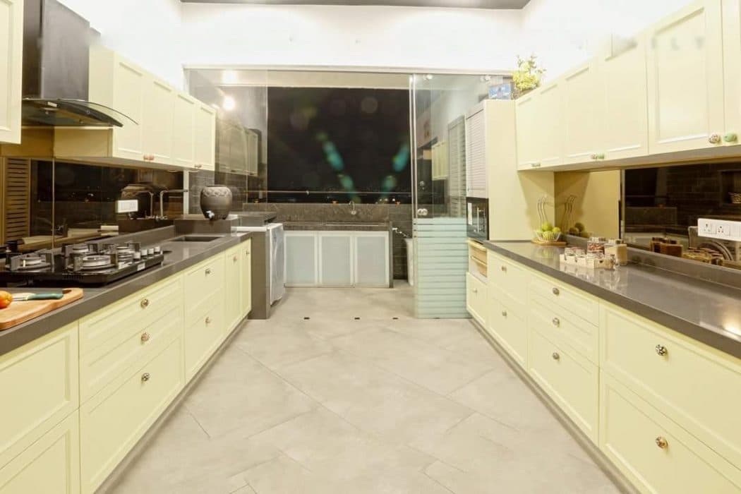 Modern-Large-Parallel-Kitchen-with-a-Glass-Portion-separating-Wash-Area.-A-Kitchen-Starts-with-a-Wooden-Storage-Unit-on-Wheels-that-highlights-a-Kind-Texts-on-Drawers-1 Design Detail Banner 0