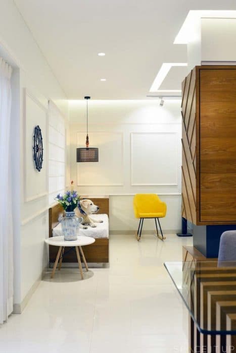 Modern-Living-Room-designed-with-Blue-Coloured-Roll-Arm-Sofa-Set-Wooden-Glass-Top-Coffee-Table-placed-on-a-Rug-Corner-Side-Table-with-Table-Lamp-Wall-mounted-T.V.-Unit-6 Swiper Content 5