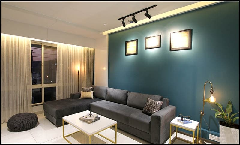 Modern-Living-Room-with-Teal-Blue-Coloured-Feature-Wall-with-Framed-Wall-Arts-highlighted-with-Track-Focus-lights-Yellow-Accents-Armchairs-2 Modern Living Room