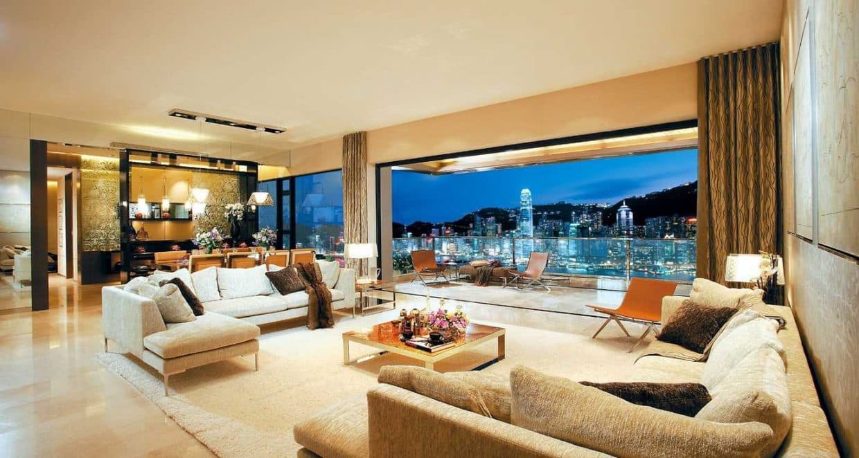 Open-Concept-Contemporary-Living-Room-designed-with-Sectional-Sofa-on-both-the-sides-Square-Metallic-Center-Table-Side-Table-with-a-Table-Lamp-on-it Design Detail Banner 0