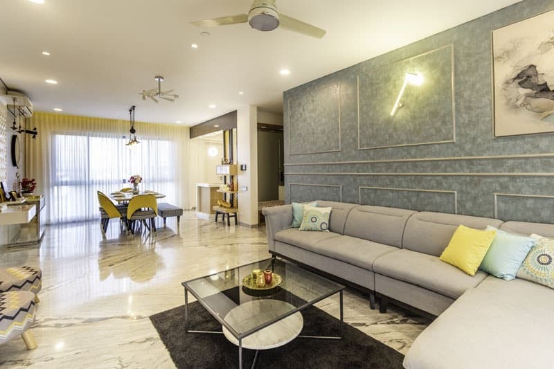 Open-Concept-Living-Dining-Room-comprises-of-Light-Grey-Shaded-Upholstered-L-Shaped-Sectional-Sofa-with-Right-Facing-Chaise-Metal-Base-Colourful-Cushions-1 Design Detail Banner 0