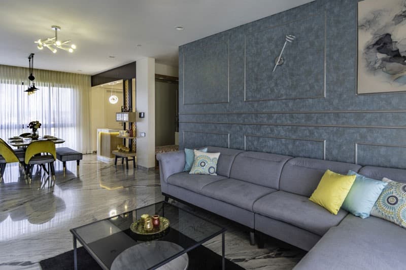 Open-Concept-Living-Dining-Room-comprises-of-Light-Grey-Shaded-Upholstered-L-Shaped-Sectional-Sofa-with-Right-Facing-Chaise-Metal-Base-Colourful-Cushions-3 Design Detail Banner 2