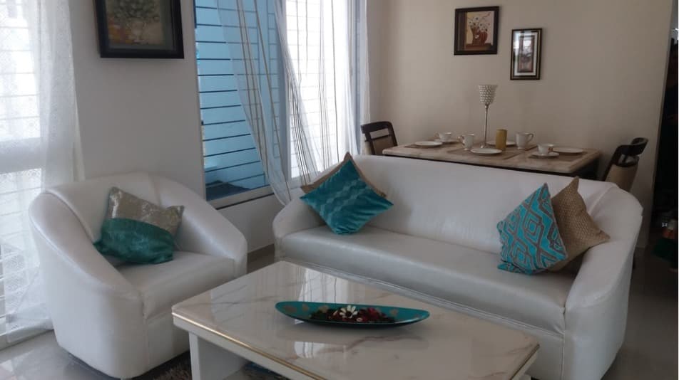 Open-Concept-Living-Dining-Room-comprises-of-White-Leather-Upholstered-Slanted-Armed-Sofa-Set-with-Printed-Cushion-Center-Table-with-Marble-Top-1 Design Detail Banner 0