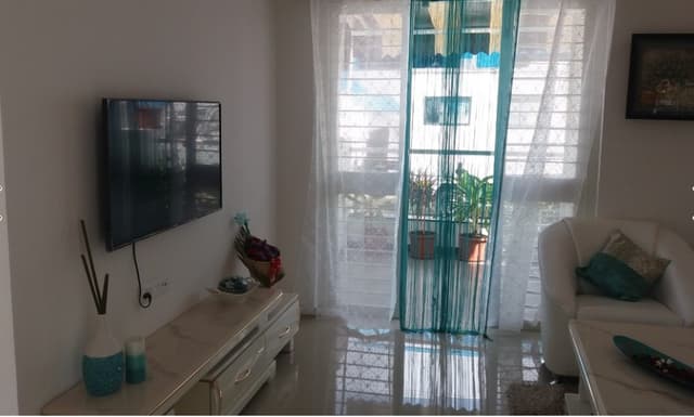 Open-Concept-Living-Dining-Room-comprises-of-White-Leather-Upholstered-Slanted-Armed-Sofa-Set-with-Printed-Cushion-Center-Table-with-Marble-Top-3 Swiper Content 2