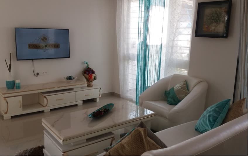 Open-Concept-Living-Dining-Room-comprises-of-White-Leather-Upholstered-Slanted-Armed-Sofa-Set-with-Printed-Cushion-Center-Table-with-Marble-Top-4 Design Detail Banner 3