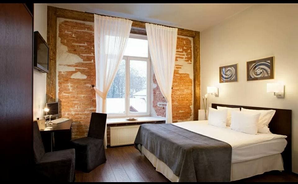 Rustic-Styled-Bedroom-with-an-Exposed-Brick-Featured-Wall-Window-in-a-Center-with-a-Center-Window-Seating-covered-with-Sheer-Curtains Design Detail Banner 0