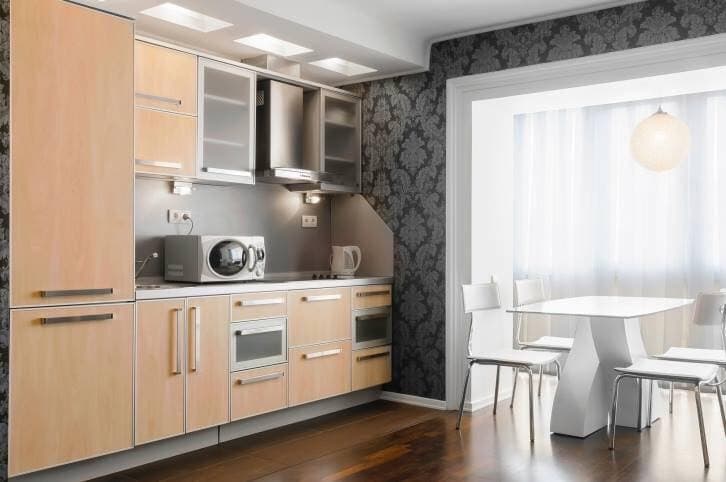 Small-Single-Wall-Kitchen-with-a-White-Dining-Table-contain-Cream-Coloured-Cabinets-SS-Handles-Few-Upper-Cabinets-with-Glazed-Shutters Small Single Wall Kitchen