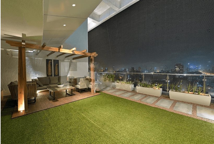 Spacious-Balcony-with-Glass-Railing-and-Stainless-Steel-Handrail-incorporates-Artificial-Turf-Flooring-Stone-Flooring-Ceiling-with-Recessed-Lights-highlighted-with-Grooves. Design Detail Banner 0