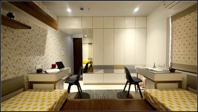 Teens-Bedroom-with-Bed-Mattress-on-Raised-Level-with-Tufted-Headboard-on-all-3-sides-of-Wall-Wooden-Flooring-Pouf-Symmetrical-Working-Desks-with-Chairs-on-both-Sides-with-Shelves-on-Wall-1 Teens Bedroom with Bed (Mattress) on Raised Level with Tufted Headboard