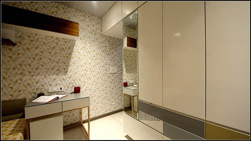 Teens-Bedroom-with-Bed-Mattress-on-Raised-Level-with-Tufted-Headboard-on-all-3-sides-of-Wall-Wooden-Flooring-Pouf-Symmetrical-Working-Desks-with-Chairs-on-both-Sides-with-Shelves-on-Wall-3 Teens Bedroom