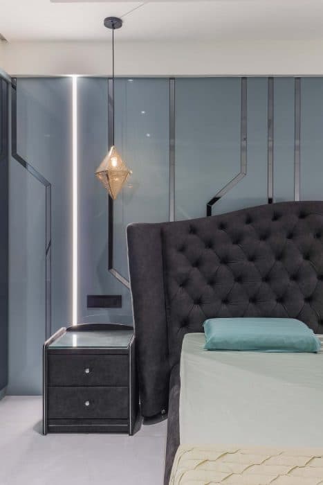 The-Bedroom-with-designer-Velvet-Fabric-covered-Double-Bed-along-with-Side-Tables-High-Wingback-Tufted-Headboard-for-back-rest-Back-Painted-Glass-on-Bed-back-Wall-WardrobeLinear-TV-Un-1 Swiper Content 2