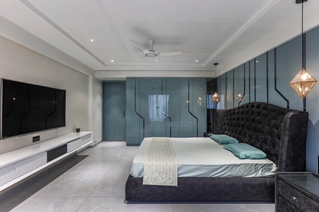 The-Bedroom-with-designer-Velvet-Fabric-covered-Double-Bed-along-with-Side-Tables-High-Wingback-Tufted-Headboard-for-back-rest-Back-Painted-Glass-on-Bed-back-Wall-WardrobeLinear-TV-Unit- Design Detail Banner 1