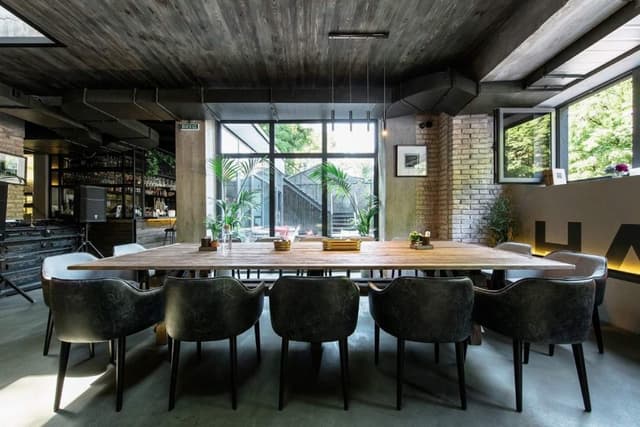 The-Rustic-Style-Bar-Space-having-14-Seater-Dining-Table-is-Placed-for-having-Group-discussions-with-Drink-food-and-for-get-together. Swiper Content 0