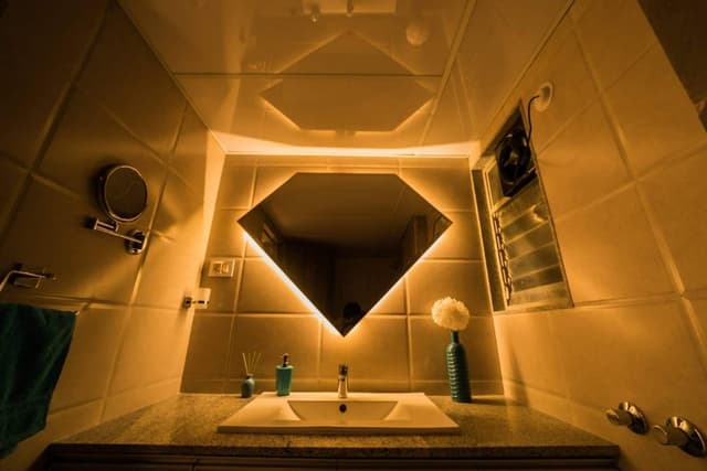 The-diamond-Shape-Mirror-having-LED-Strip-Light-is-adding-Drama-to-the-Space-making-this-Unit-Interesting-in-the-Bathroom. Swiper Content 0