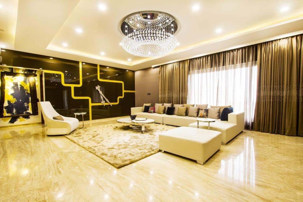 This-Luxurious-Living-Space-Consists-White-Sectional-Sofa-with-Cushions.-Multilevel-Circular-Center-Table-with-Metal-Frame-Floor-Rug-is-Functionally-Supporting-the-Space.-1 Design Detail Banner 0