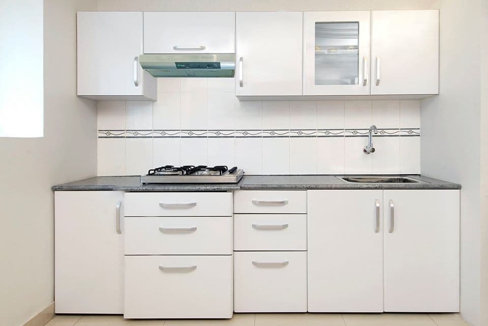 This-Small-White-Kitchen-Consists-Linear-Platform-with-Granite-Top-having-4-Burner-Gas-Stove-with-Chimney Design Detail Banner 0