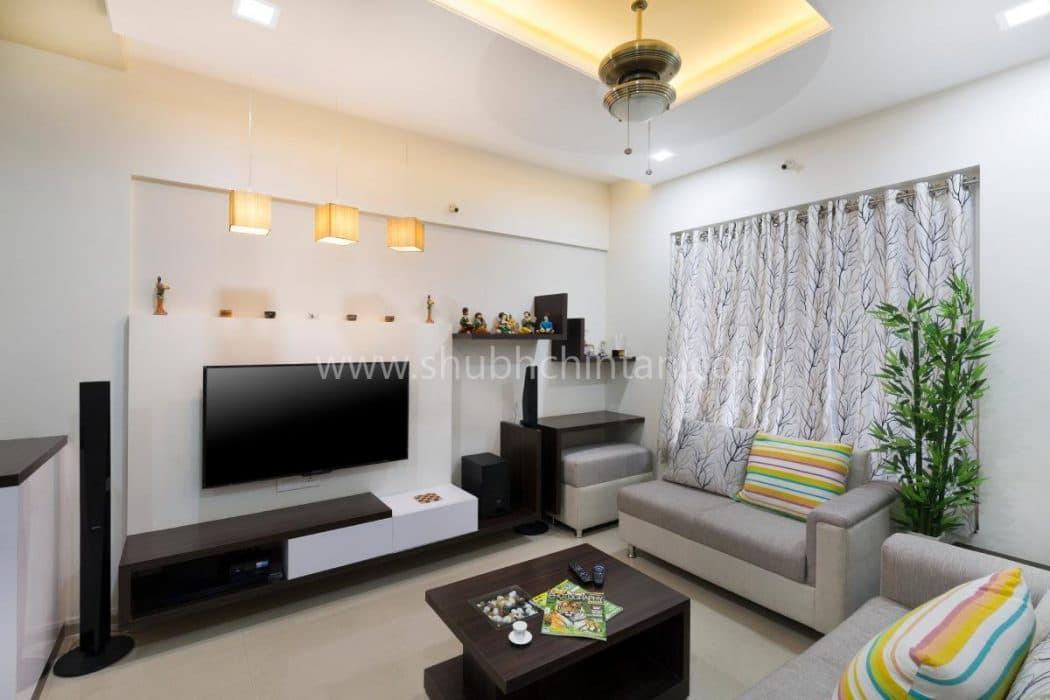 White-Coloured-Small-Living-Room-designed-with-Wall-Mounted-T.V.-Unit-Square-Armed-Sectional-Sofa Design Detail Banner 1