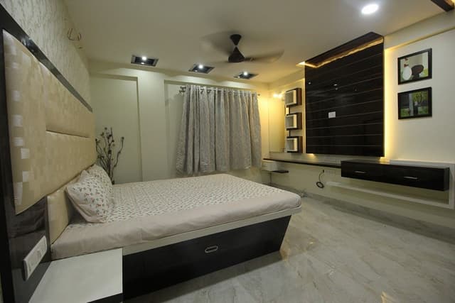 Bedroom designed with Wooden Bed, Side Tables attached with High Cushioned Headboard – 2 Swiper Content 1