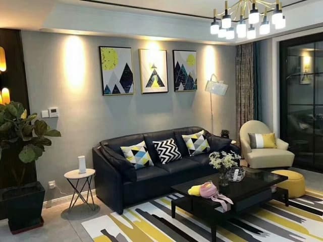 Small Contemporary Living Room designed with Black Coloured Leather upholstered Sofa, Off-white Coloured Sofa Chair, Glass Top Rectangular Wooden Coffee Table placed on a Rug Small Contemporary Living Room designed with Black Coloured Leather upholstered Sofa, Off-white Coloured Sofa Chair, Glass Top Rectangular Wooden Coffee Table placed on a Rug