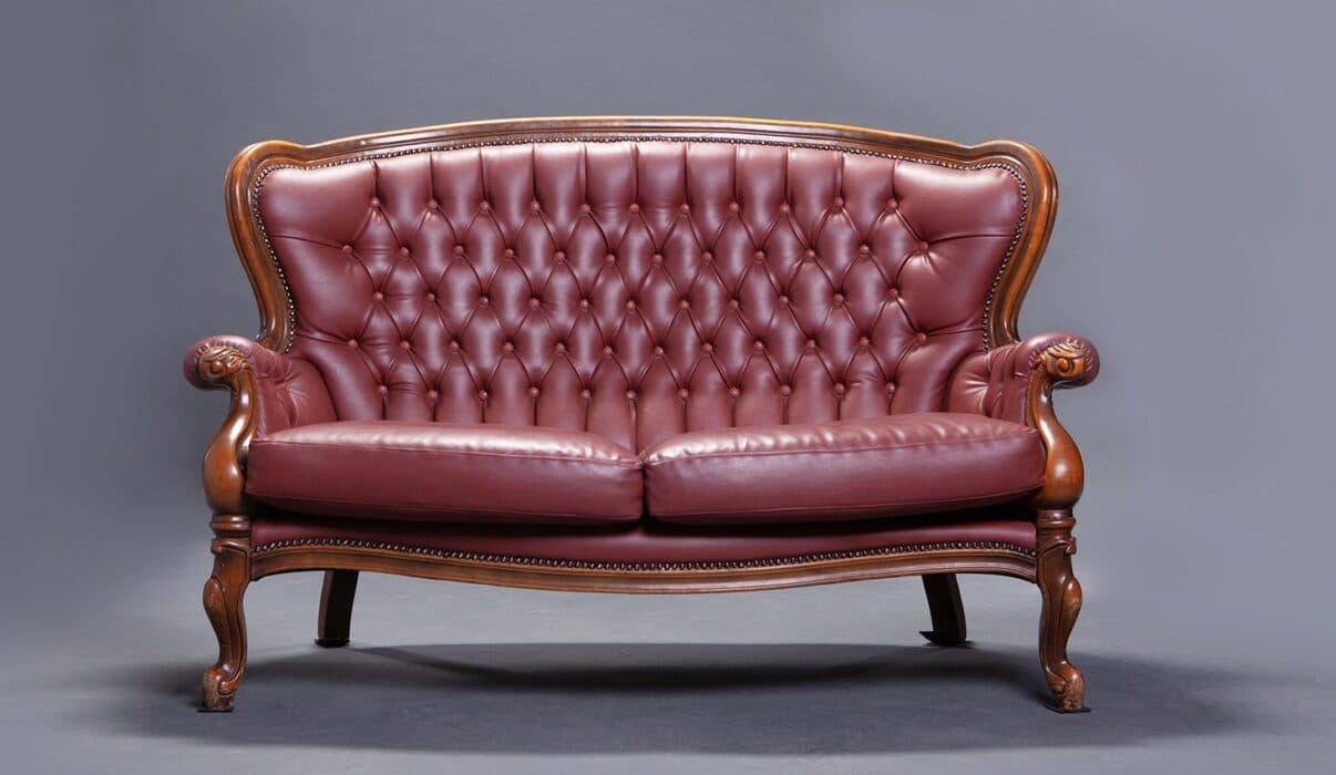A vintage Victorian-style sofa in maroon leather A vintage Victorian-style sofa in maroon leather