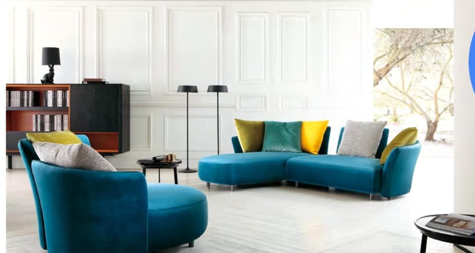 A Blue Upholstered Sofa having Beautiful Curves is Making Good Contrast with the Colourful Cushions A Blue Upholstered Sofa having Beautiful Curves is Making Good Contrast with the Colourful Cushions