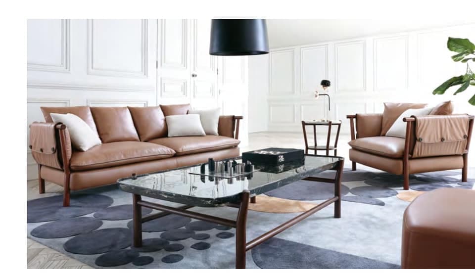 The 3-Seater & Single Seater Brown Leather Upholstered Sofa having Wooden Framed Legs are Nicely placed in the Living Room The 3-Seater & Single Seater Brown Leather Upholstered Sofa having Wooden Framed Legs are Nicely placed in the Living Room